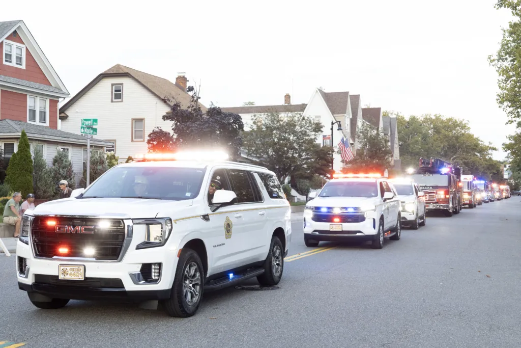 RVCFD Chief vehicles and fire apparatus traveling in a department procession through Rockville Centre.