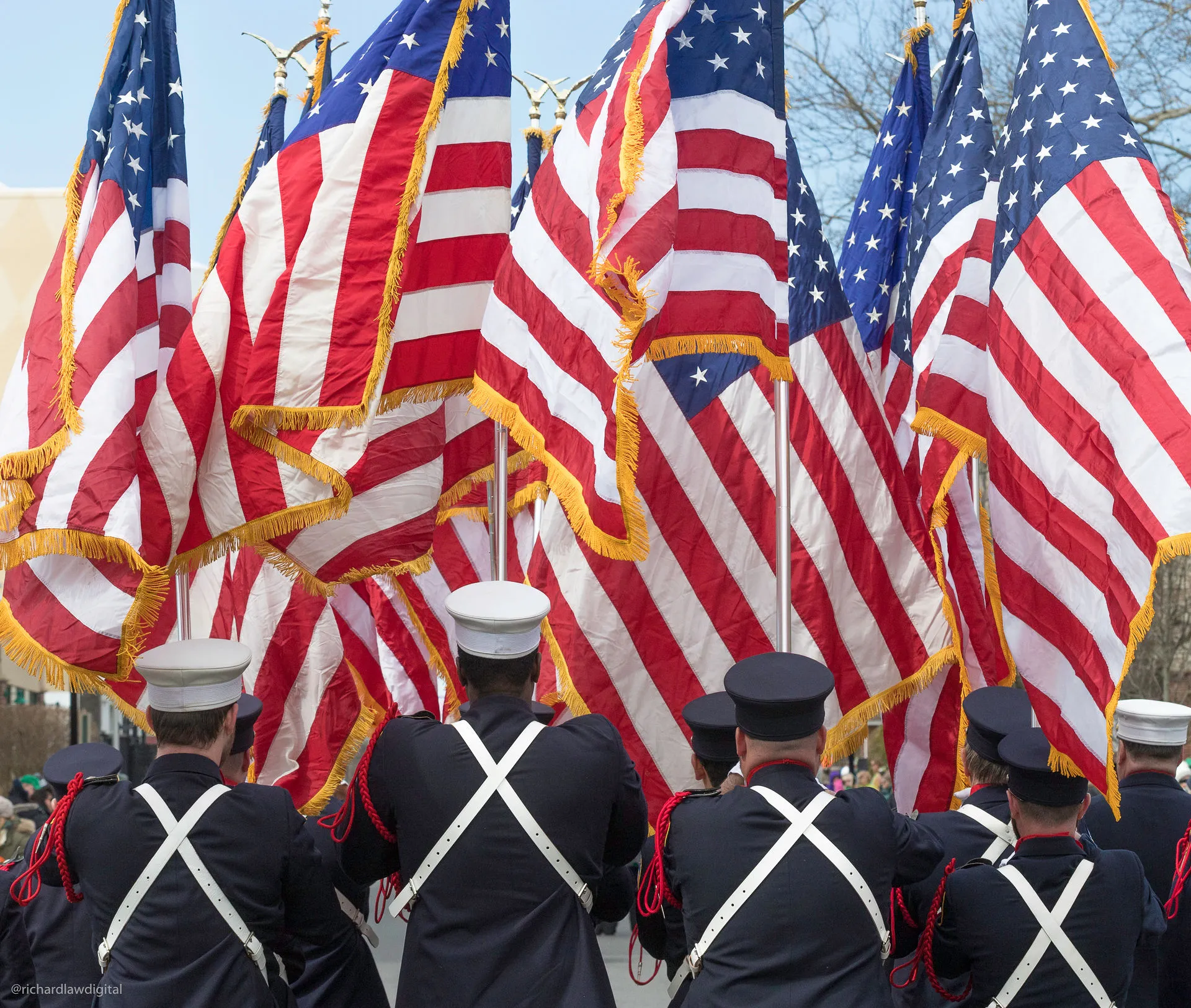 Rockville Centre Fire Department members standing beneath American flags