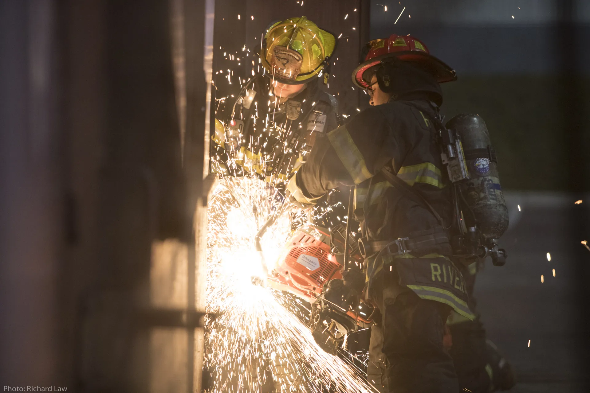 Rockville Centre firefighters using a power saw during training